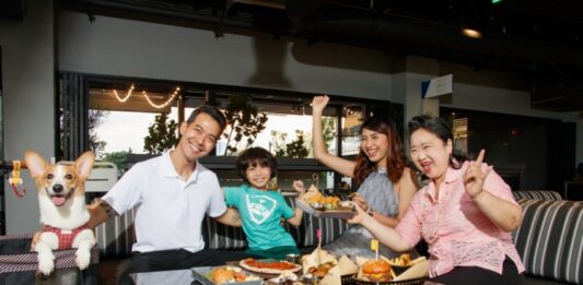 สร้างช่วงเวลาดี ๆ และฉลองวันแม่ปีนี้ที่ ท็อปกอล์ฟ เมกาซิตี้กันเถอะ! A group of people sitting at a table with food Description automatically generated