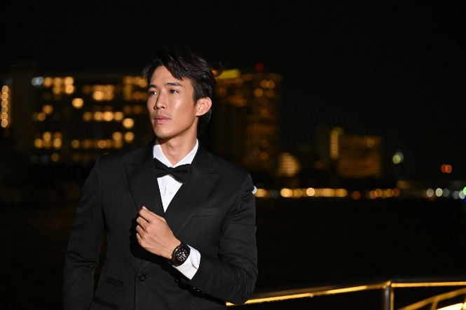 A person in a suit and bow tie Description automatically generated