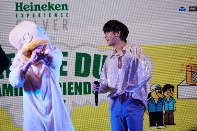 A person in garment on stage with microphone Description automatically generated