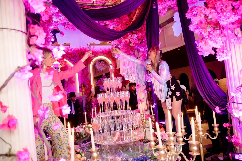 A group of people standing around a table with champagne glasses
Description automatically generated